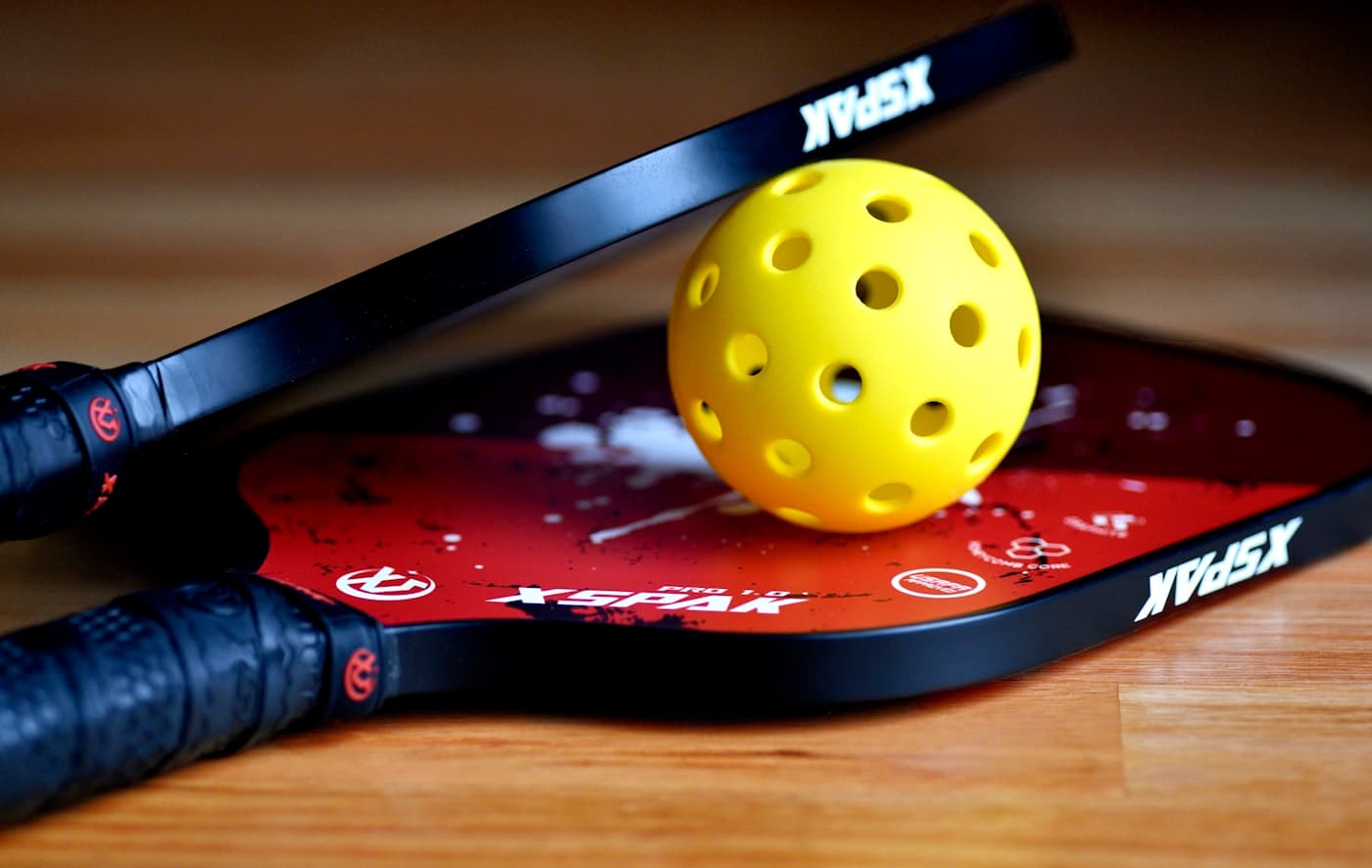 Close-up of a pickleball resting on a paddle